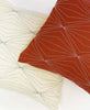 coordinating modern throw pillows in ivory and rust orange featuring hand-embroidery