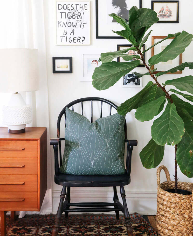 spruce geometric pattern pillow styled on a wooden chair in a modern eclectic home