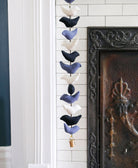 Monochromatic bell tota in black, blue and white hanging against white tiled fireplace