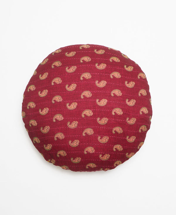 Round burgundy vintage kantha throw pillow featuring a tan paisley print 