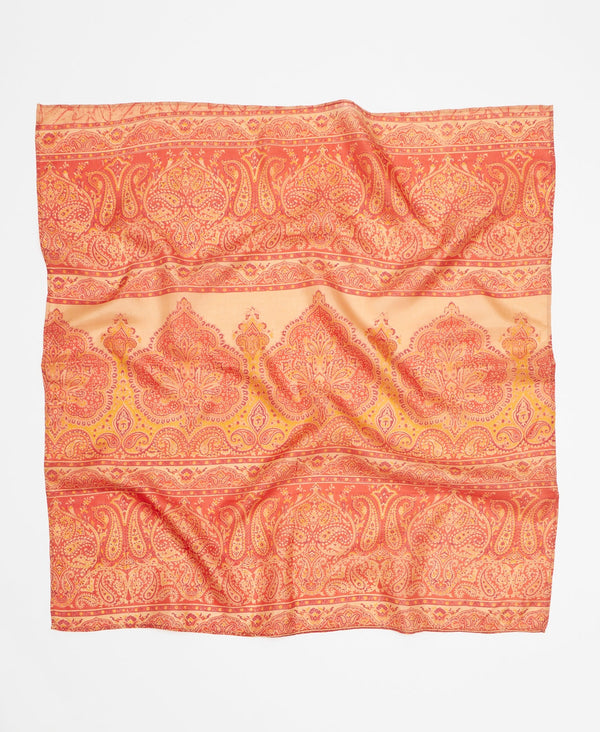 Vibrant silk square scarf featuring a peach, orange and yellow paisley pattern. 