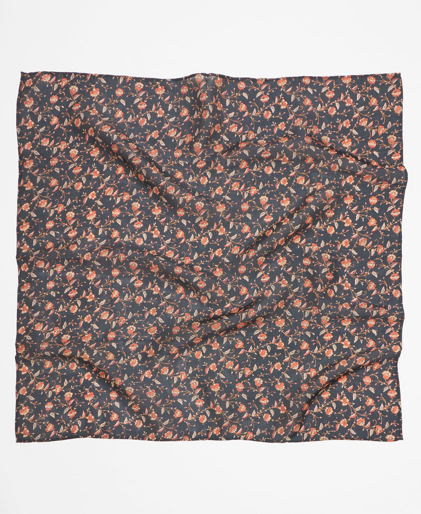 Black silk square scarf featuring an intricate white and muted orange floral pattern  