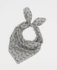 White silk square scarf featuring a black paisley pattern 