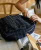 unzipping small canvas black backpack on kitchen table