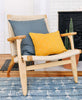 mid-century modern wooden chair with geometric colorful pillows
