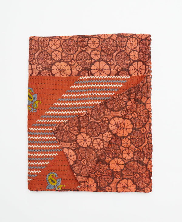 Deep orange red colored cotton small throw blanket that features a floral design and unique small chevron print