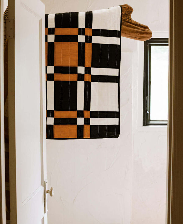 black and white checkered quilt throw by Anchal hanging as wall tapestry