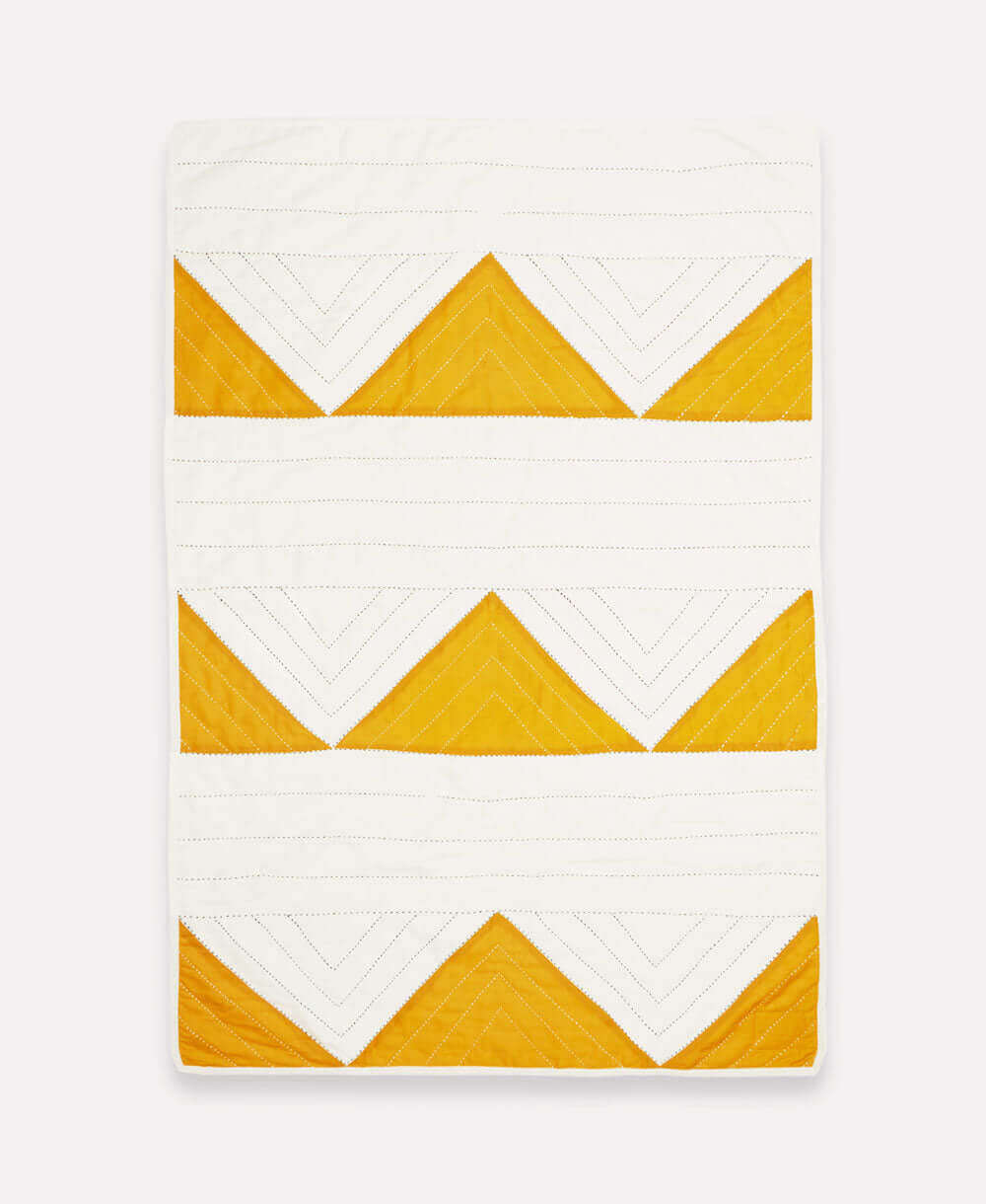 hand quilted organic cotton baby blanket with mustard yellow triangles