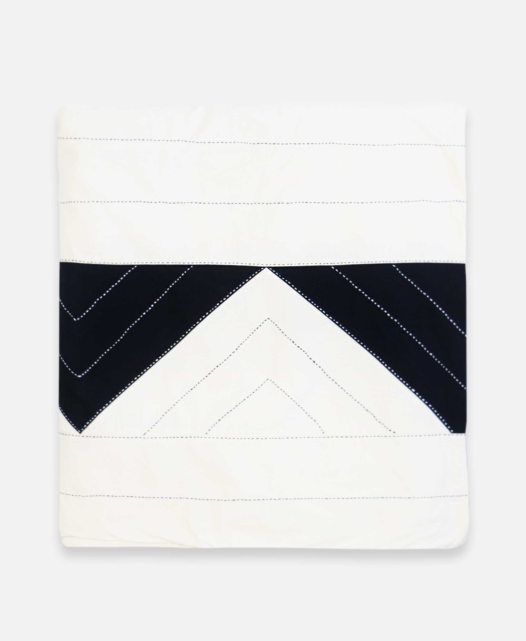 Folded duvet cover showcasing intricate bone and charcoal stitching and patterns