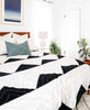 Bone and charcoal geometric bedding styled in a bedroom with coordinated pillow arrangement