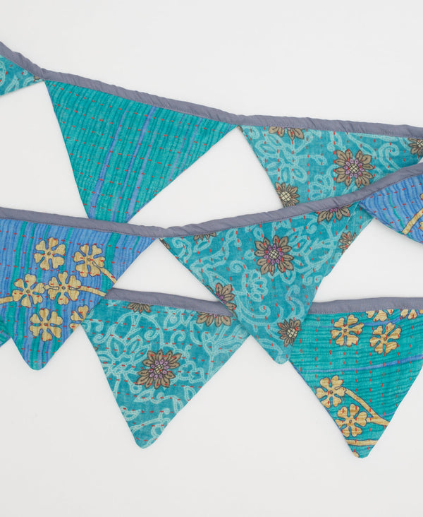 blue fair trade triangle flag garland with floral details and red  kantha stitching 