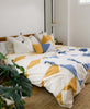 mustard yellow and white triangle duvet cover with hand-stitched embroidery in modern boho bedroom