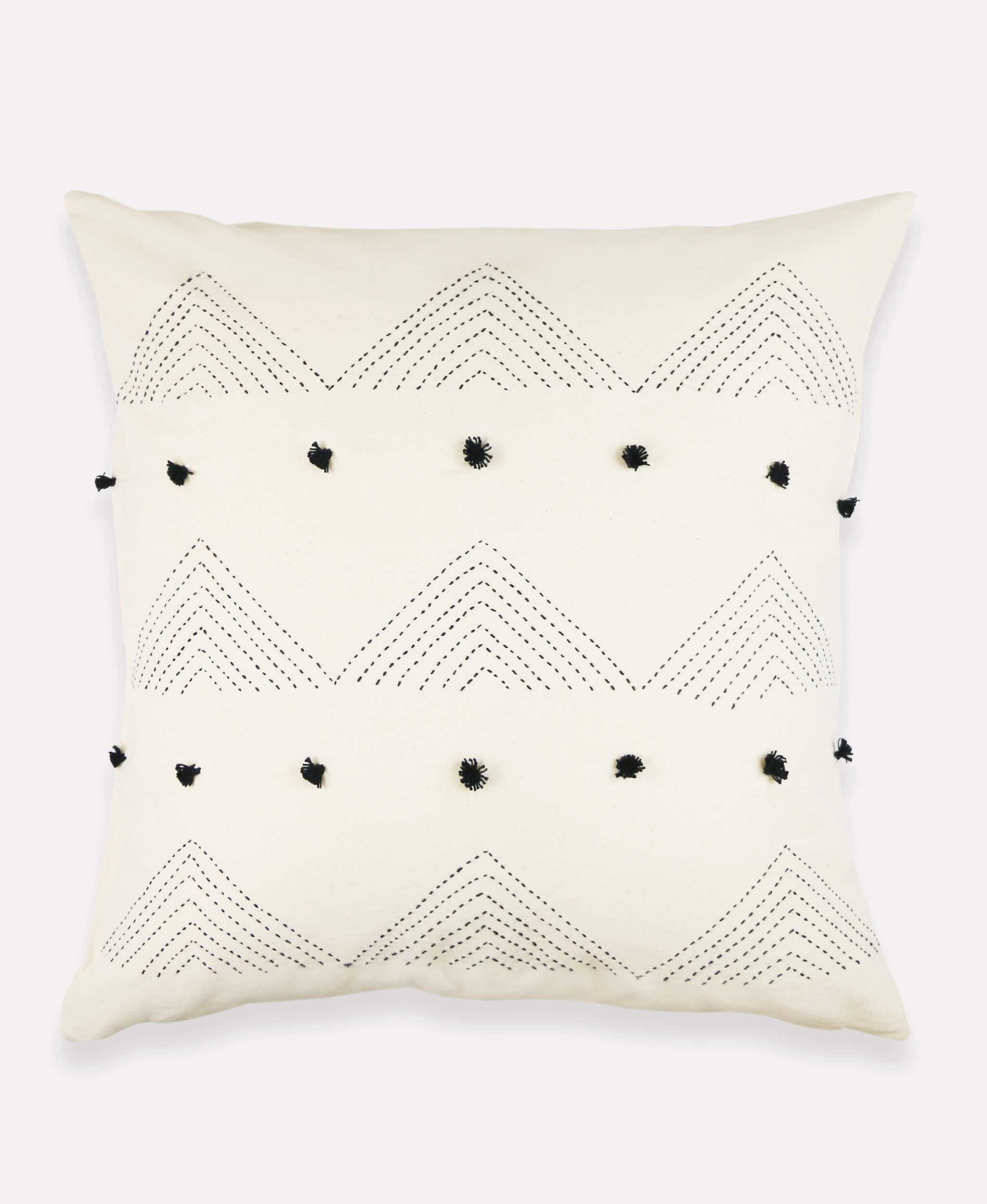 Embroidered throw pillow in natural white with black pom poms