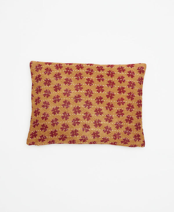 tan ecofriendly throw pillow with small red flowers handstitched using white kantha thread by a woman artisan in Ajmer, India