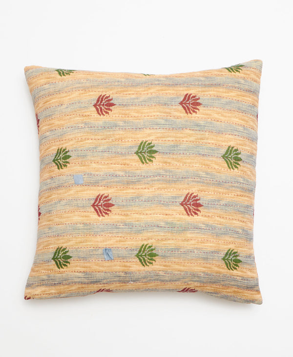 Opposite side of pillow featuring a beige and blue faded stripe pattern 
