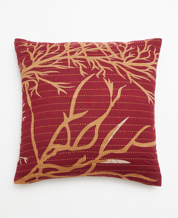 Opposite side of pillow featuring a tan branch pattern on a burgundy background