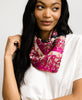 woman in white shirt wearing a bright pink Anchal bandana tied around her neck